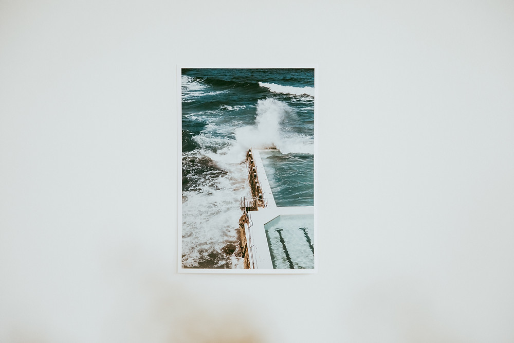 a wave crashes over the corner of the iconic Bondi Icebergs rockpool, Bondi Beach, Sydney.