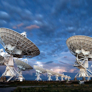 A group of large satellite dish-like objects. A radio telescope array.