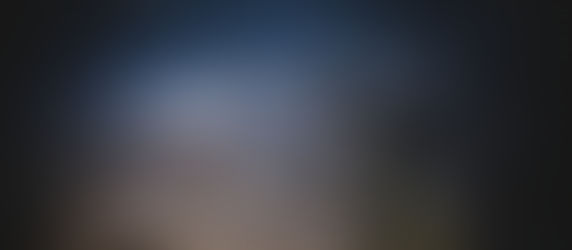A small telescope with a thin tube before a Milky Way backdrop.