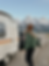 A custom retro style teardrop camper set up near snow capped mountains