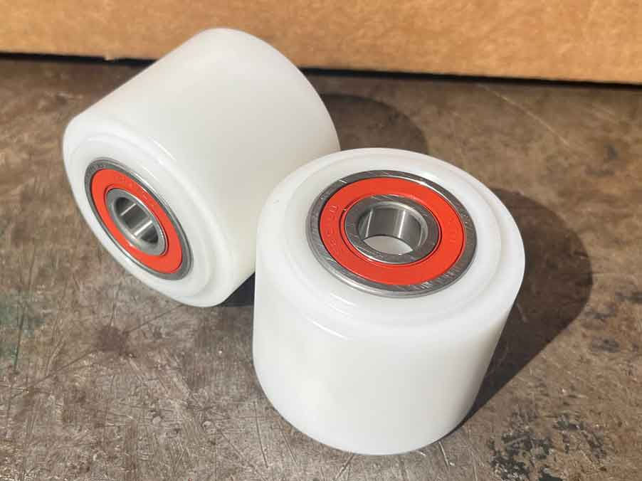 Close-up of custom CNC machined roller bodies with bearings fitted ready for use.