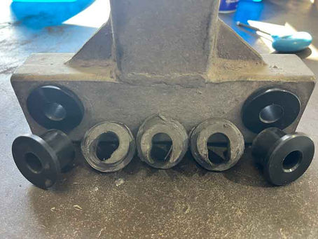 New custom nylon bushes shown beside worn original trailer suspension bushes used as reverse engineering templates.