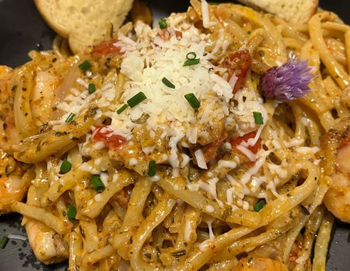 Creamy seafood pasta dish with slices of bread on the side