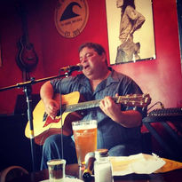 Man playing guitar at The Groundswell Pub