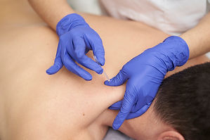 Patient prone, dry needling upper traps.