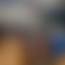 Clothing racks with various sizes are displayed in a gym. A child in pink and adults browse clothes. Signs read "Large" and "Extra Large."