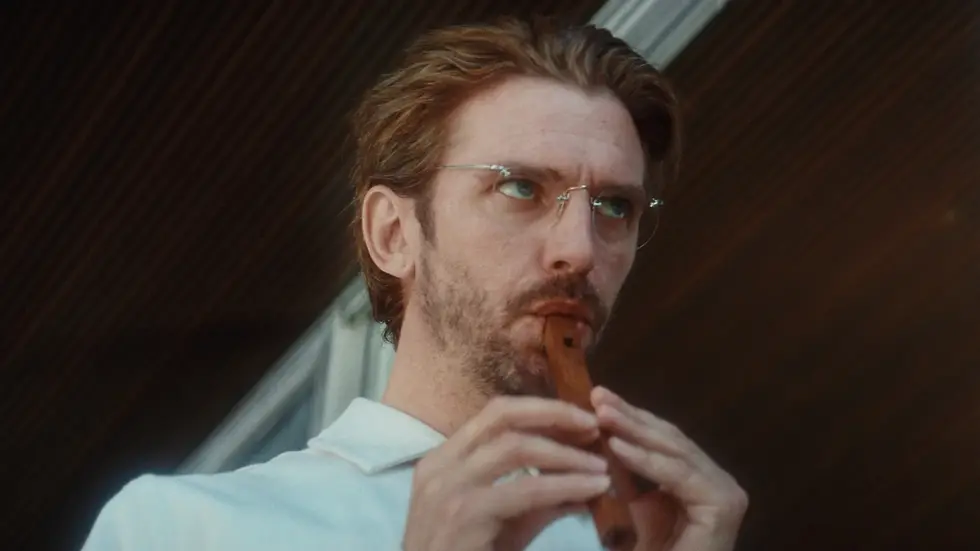 Un hombre de lentes tocando la flauta.