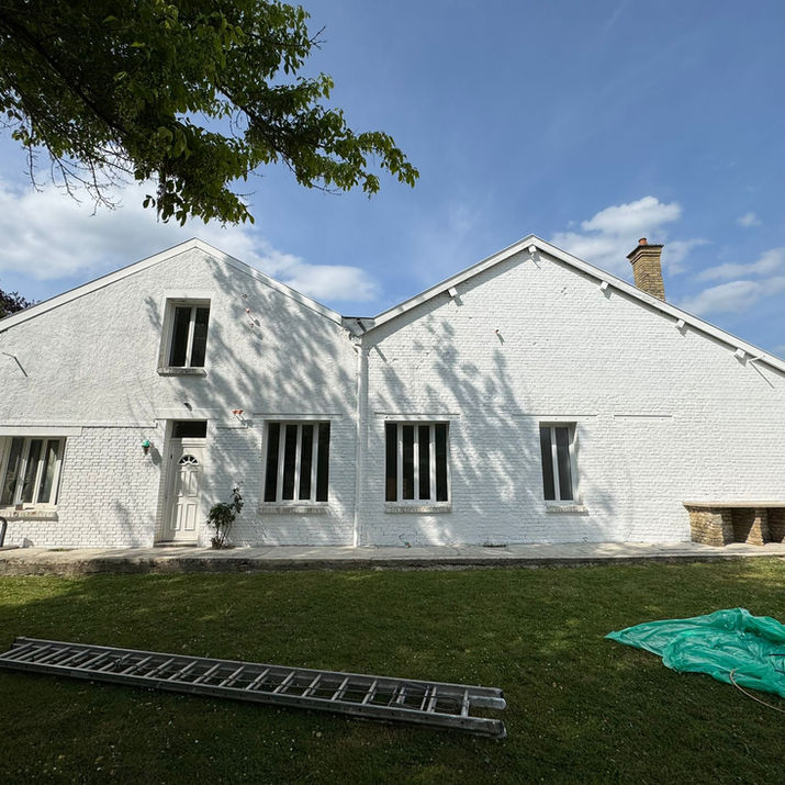Façade de maison rénovée à Attigny 08130 avec peinture extérieure blanche.