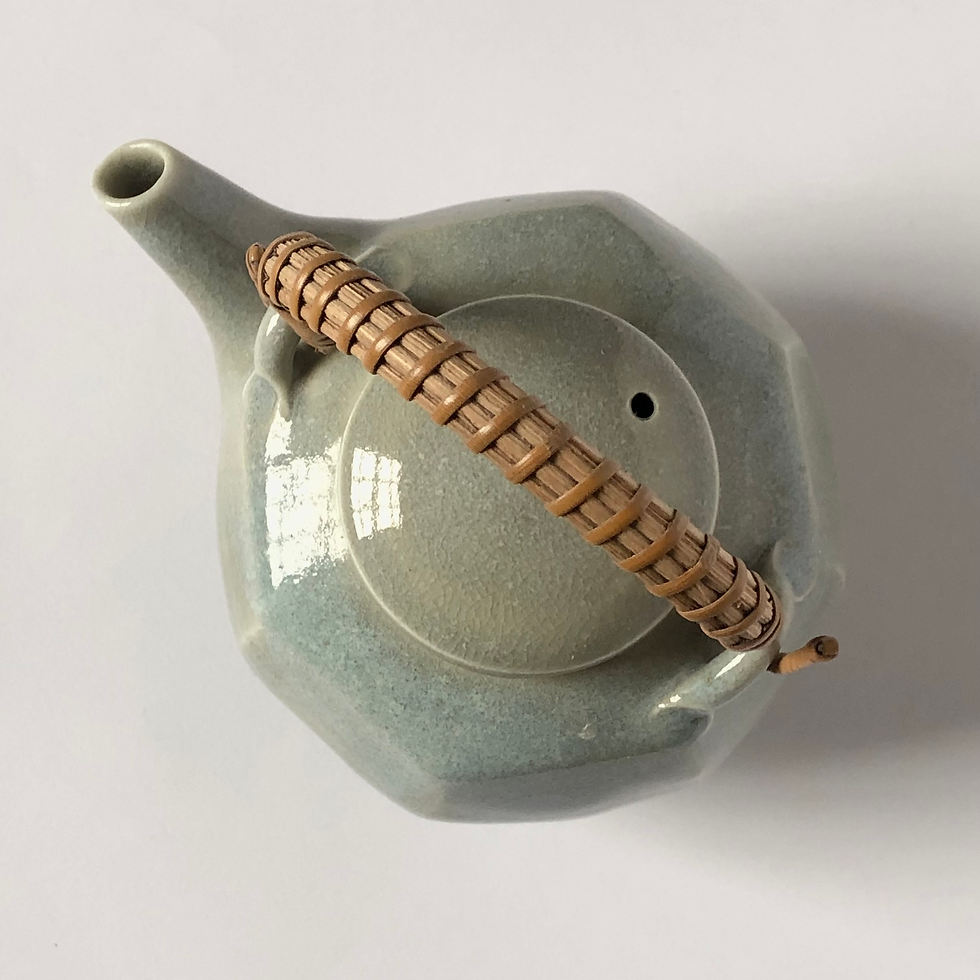 Thumbnail: A  porcelain cut sided teapot with a cane handle.