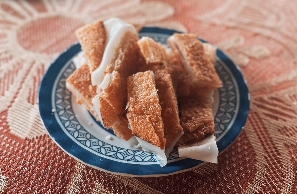 Slices of golden brown bread topped with a white spread on a blue-patterned plate, set on a textured orange tablecloth.