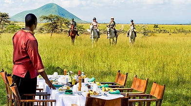 People on safari riding horseback to lunch