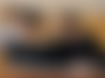 Two students sat beside each other in a lecture hall, both making notes.