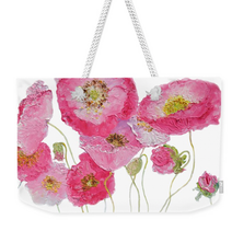 A tote bag with pink poppies on a white background