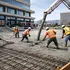 Workers pouring commercial concrete foundation with reinforced rebar system
