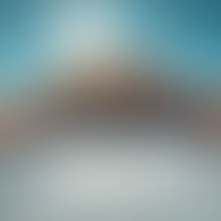 A house alongside blueprints and a roll of paper, representing the construction permit requirements in the Bay Area.