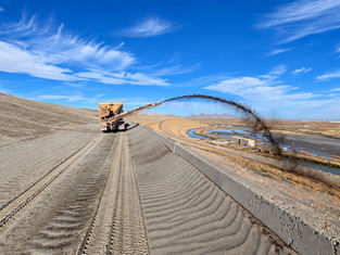 Conveyor truck spreading compost across the Kennecott tailings embankment in Utah