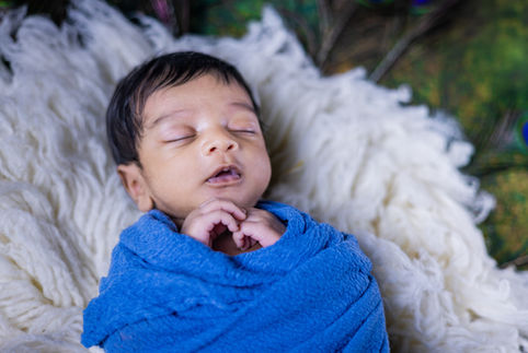 Newborn baby boy wrapped in soft swaddle blanket – best newborn photography in Vizag