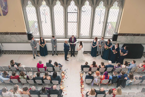 a bride and groom are getting married in front of a large window