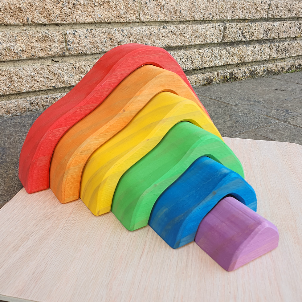 Thumbnail: Rainbow-colored wooden stacking toy on a wooden surface. Serenitoys.