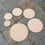 Thumbnail: Various sized wooden circles arranged on a stone tile surface for crafting or art.