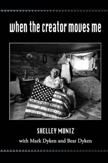 Book cover for 'When the Creator Moves Me' by Shelley Muniz, black-and-white photo of an elder woman holding an American flag quilt, portrait cover.