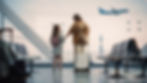 Woman and girl with luggage watch a plane through an airport window, suggesting an excited family trip