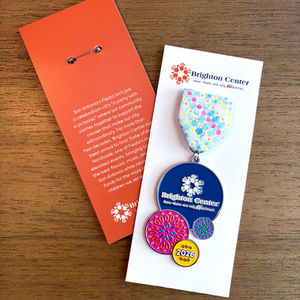 Colorful medal with geometric patterns on a wooden surface.