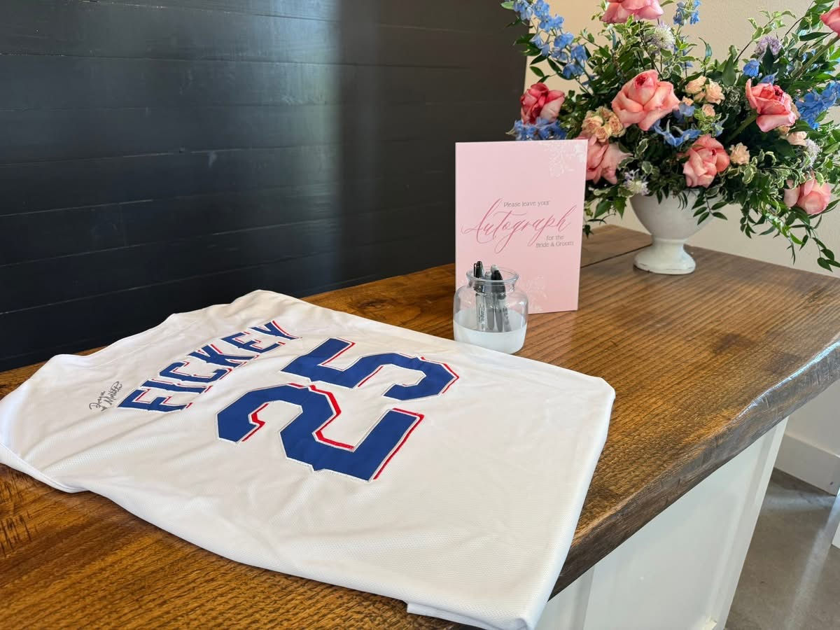 Baseball jersey on table with flowers and card.