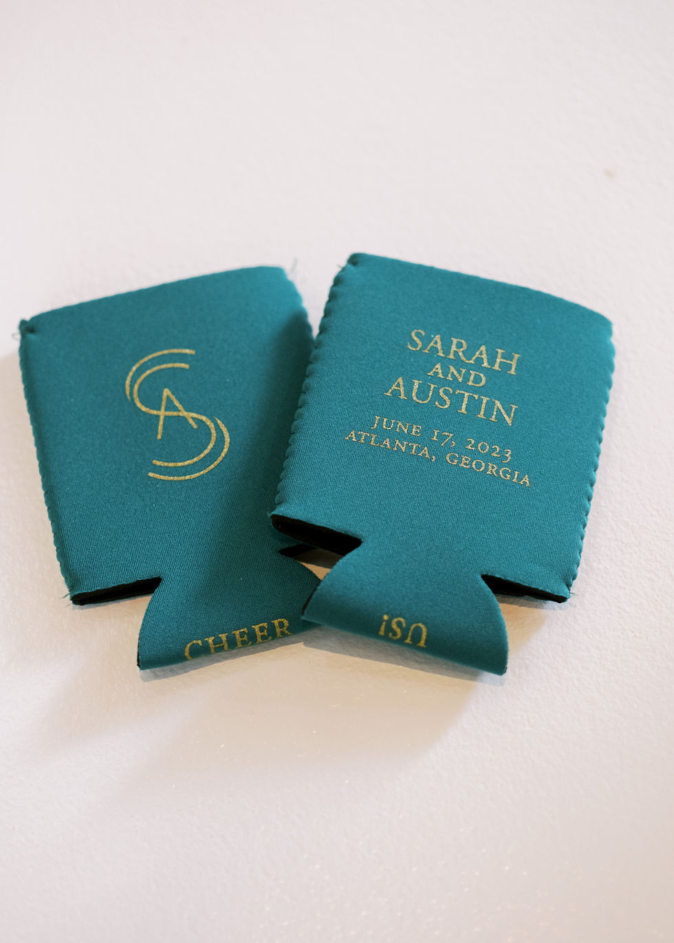Teal drink koozies with gold text and initials.
