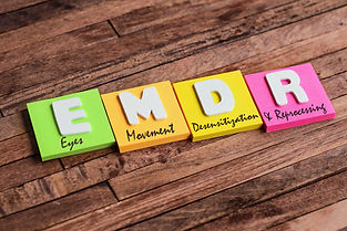 Colorful square papers with wooden white letters for the English acronym word, EMDR.jpg