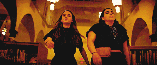 Molly and Amy from Booksmart walking through the library