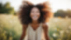 Smiling woman with defined, natural curls lit by soft daylight