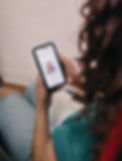 curly client looking at uninhibited curls website on her phone