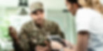 man in military uniform talking to a healthcare professional
