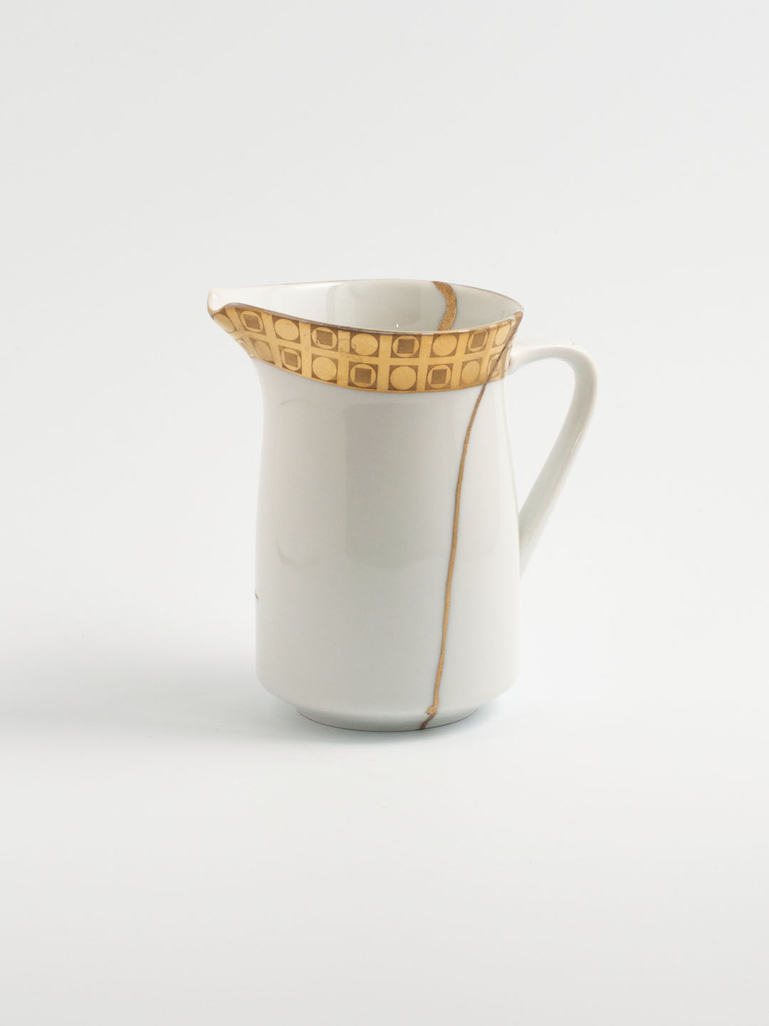 Milchkännchen aus Porzellan, repariert mit Kintsugi-Technik, weiß mit goldenem Design am Rand, Brüche mit echtem Gold veredel