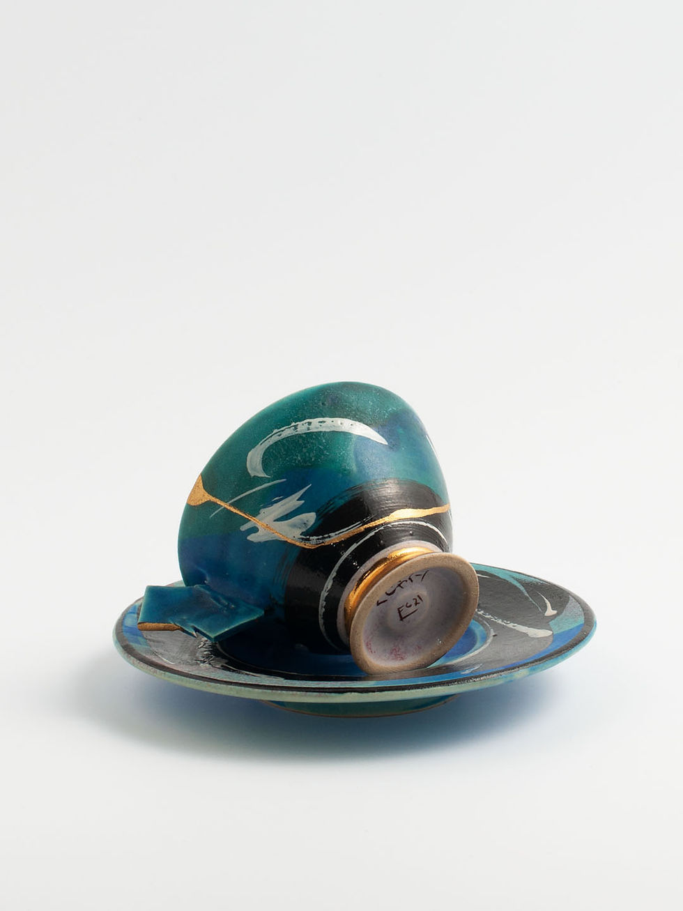 Miniaturbild: Mit der Kintsugi-Technik reparierte Keramiktasse. 80er-Jahre-Dekor mit goldenem Sockel und goldfarbenen Brüchen.