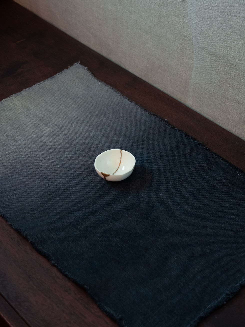 Kleine, mit Kintsugi reparierte Porzellan-Teetasse, dargestellt mit Cha-Fu-Tusche in einem Farbverlauf von Dunkelblau zu Grau