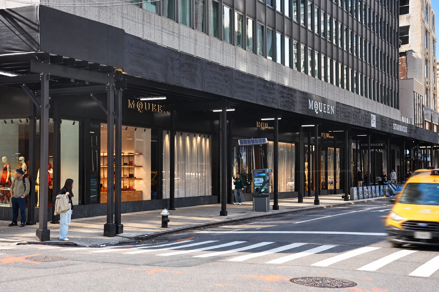 Black sidewalk shed structure alongside the storefronts at 600 Madison Avenue