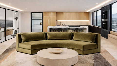 Modern living room with green sofa and round table.