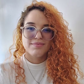 Foto da arquiteta Adrielle Gaspar com seu icônico cabelo Laranja e seu óculos grande.
