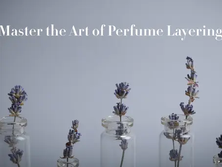 "Minimalist composition of glass perfume bottles with dried lavender flowers, symbolizing the art of perfume layering."
