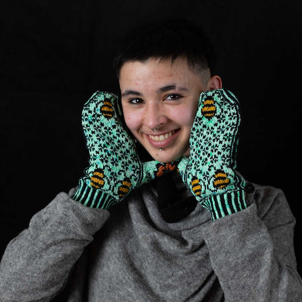 Thumbnail: Model face framed by bright green mittens with bees on them