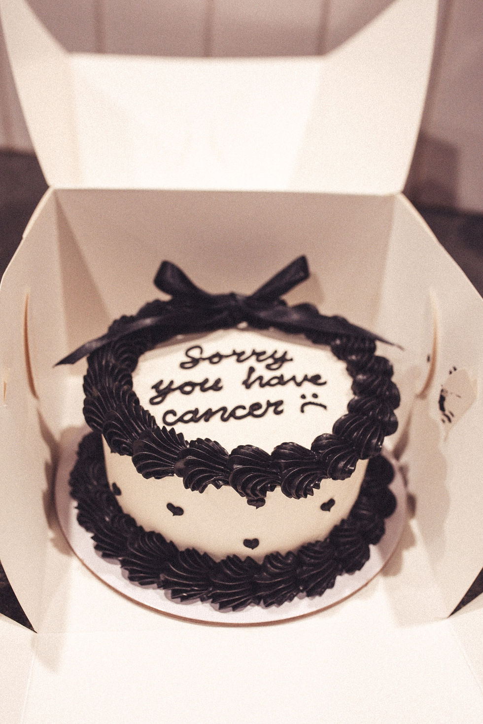A cake with icing that says sorry you have cancer.
