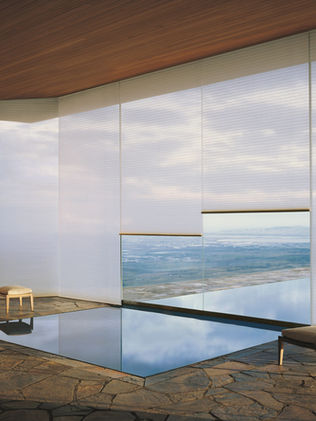 Sheer Honeycomb Shades one large floor to ceiling windows in a media room overlooking a landscape and outdoor pool