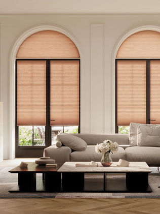 Burnt orange solar honeycomb shades from hunter douglas on arched French Doors in living room