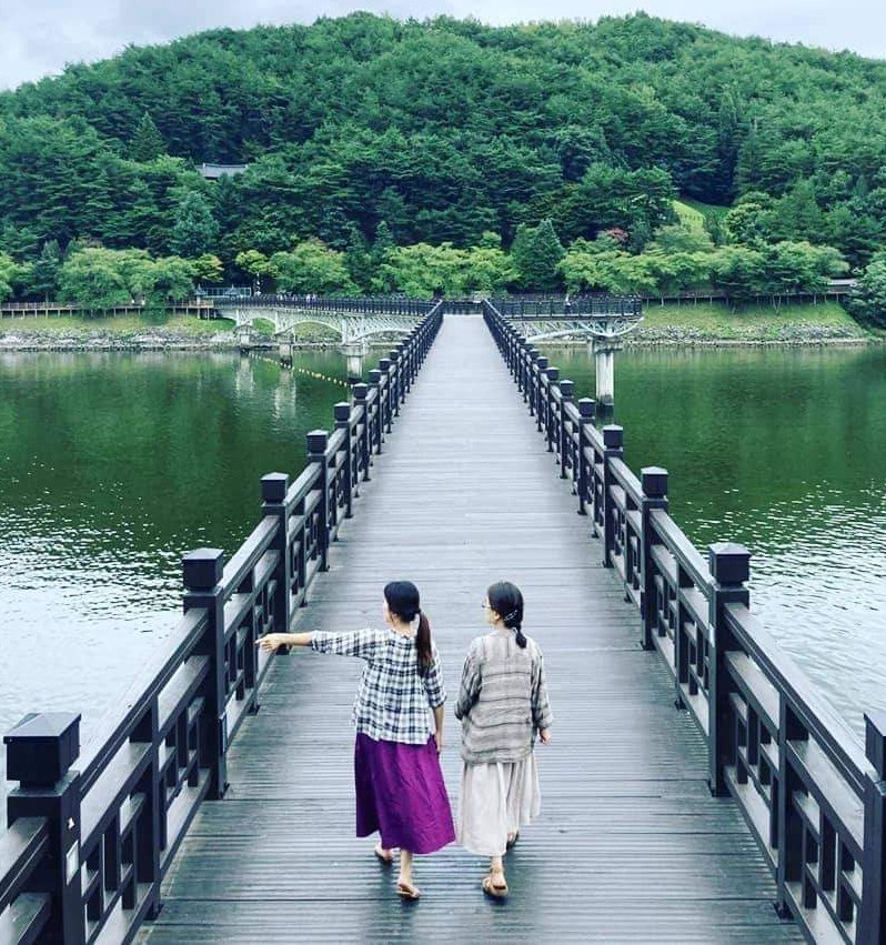 two women walking on a bridge