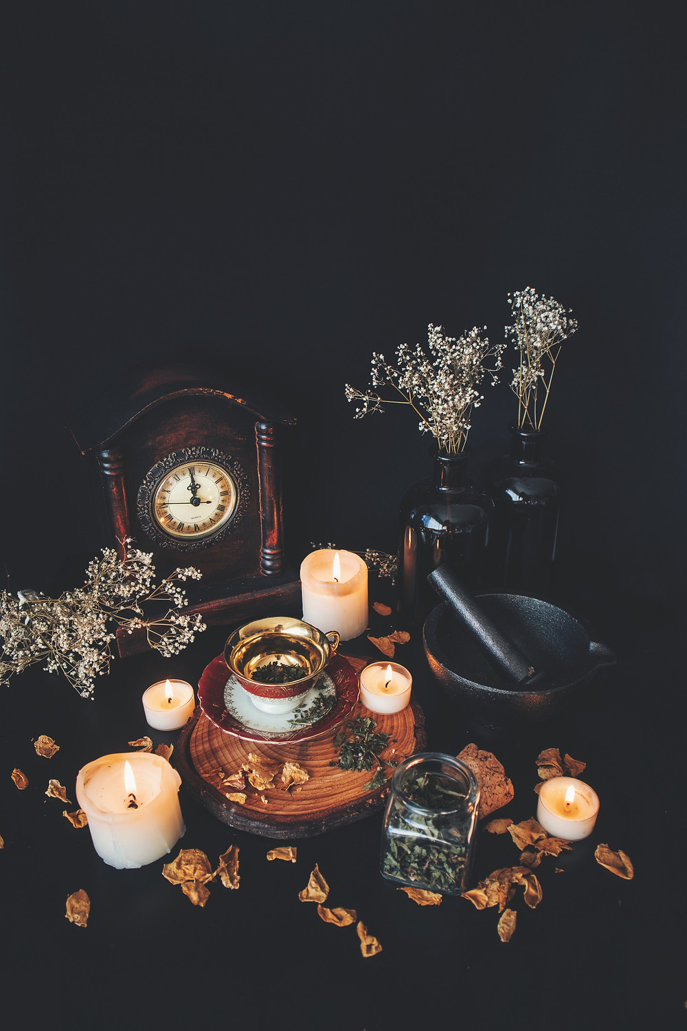 clock, candles, dried herbs and flowers, pestle and mortar