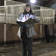 Person outside stables reading a story aloud in winter