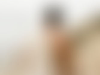 Man with a towel over his shoulder walking up a Santa Cruz beach