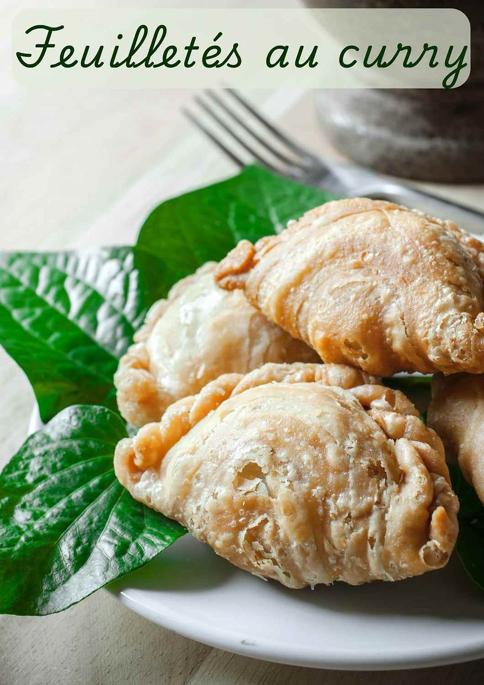 Assiette de feuilletés de patate douce au curry, dorés et croustillants, posés sur des feuilles vertes — en-cas de street food thaïe.
